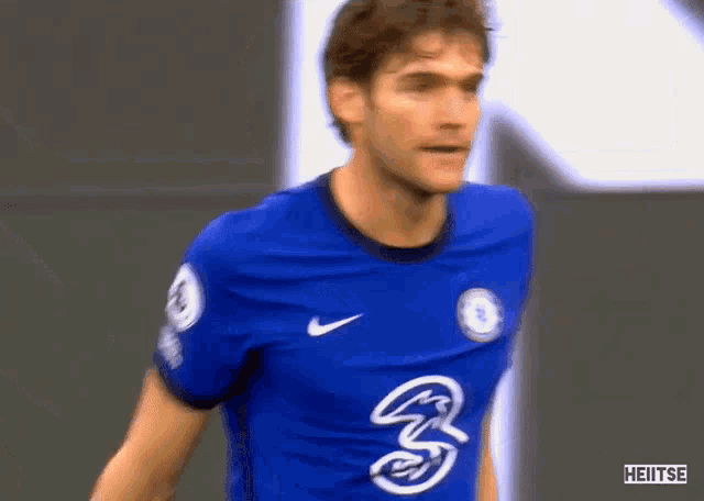 a soccer player wearing a blue shirt with the number 3 on it .