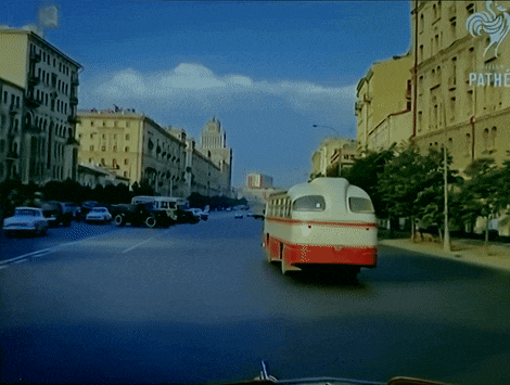 a bus is driving down a city street with pathe written in the corner