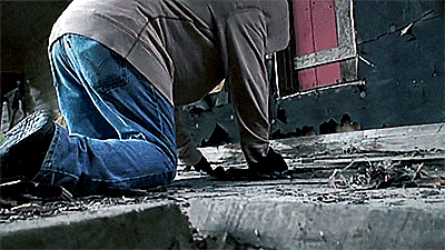 a man is kneeling down on a concrete surface
