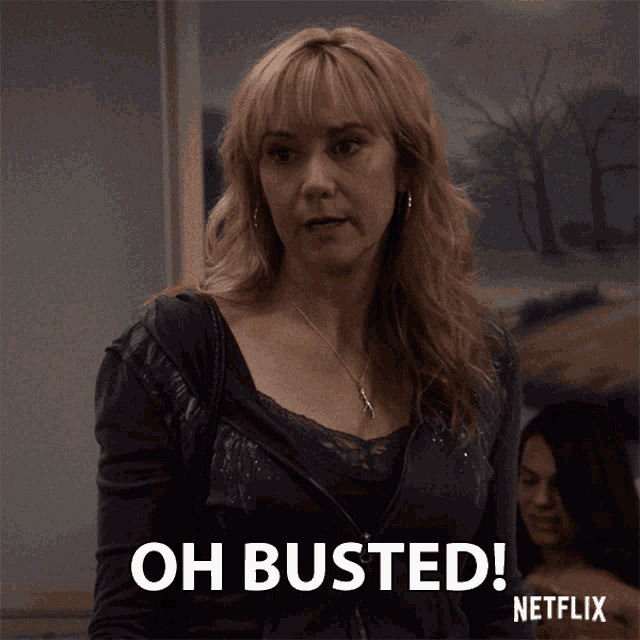 a woman says oh busted in front of a picture