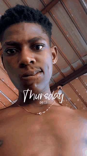 a shirtless man is looking at the camera with the date of thursday on his chest