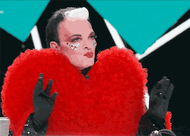 a man wearing a red heart shaped fur coat and black gloves
