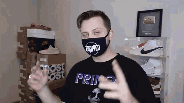 a man wearing a mask and a shirt that says prince giving the middle finger