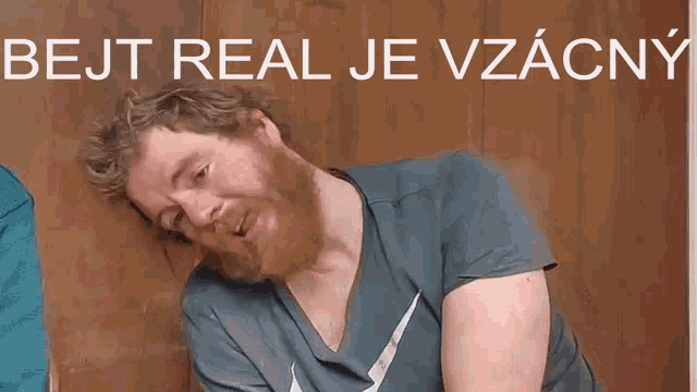 a man with a beard is smoking a cigarette with the words bejt real je vzacny above him