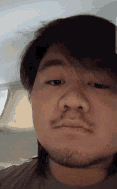 a close up of a man 's face with a lamp behind him