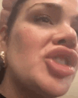 a woman is making a funny face with her mouth open .