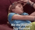 a girl is laying on a couch with her hand on her forehead and the words `` no me toques , soy famosa ''