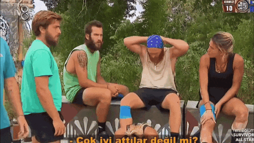 a group of people are sitting in front of a sign that says ' survivor all star '