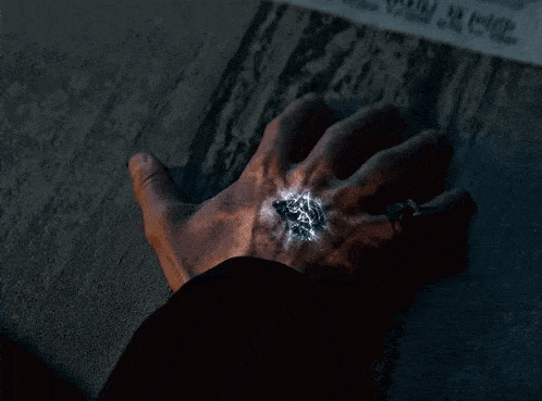 a close up of a person 's hand with a glowing object in it