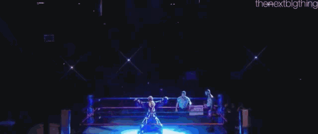 a man with a beard is dancing on a stage in a blue dress .