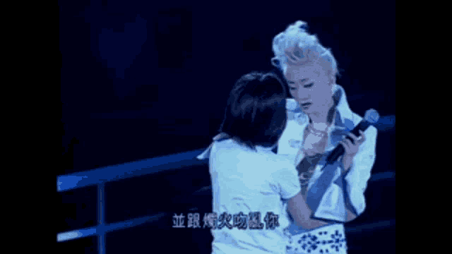 a woman is holding another woman 's arm while singing into a microphone