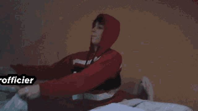 a person wearing a red hoodie with the word farofficier on the bottom