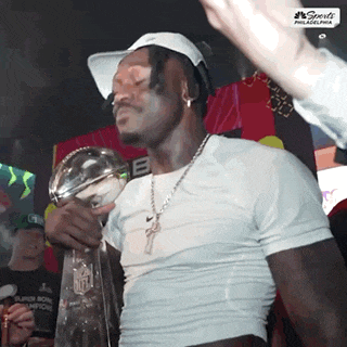a man holding a trophy that says super bowl champions