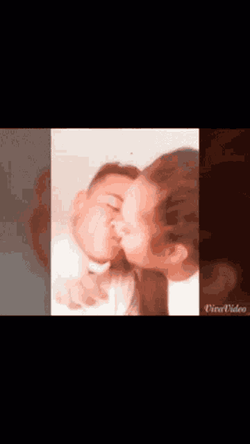 a man and a woman are kissing in a video taken by a third person