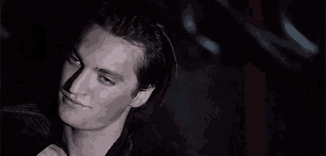 a close up of a man 's face in the dark with his eyes closed