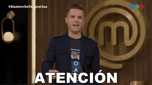 a man in a suit stands in front of a masterchef logo and says atencion