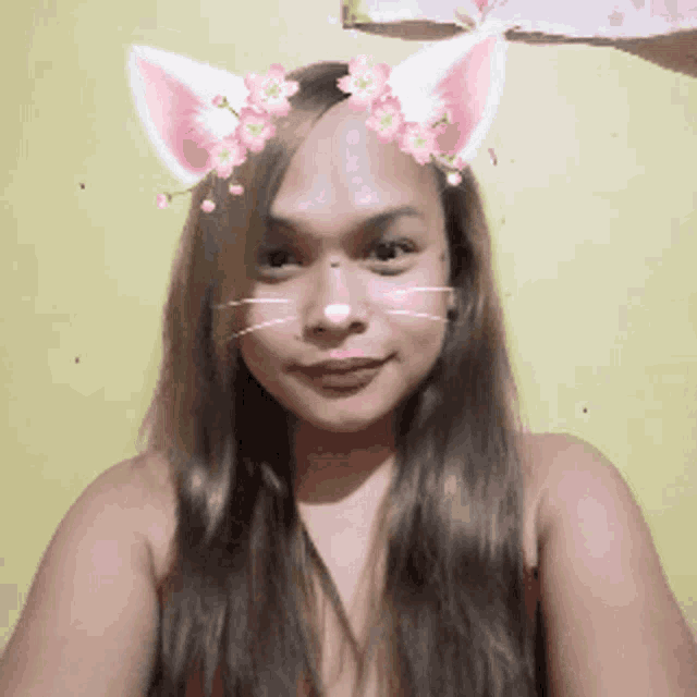 a woman wearing cat ears and flowers on her face