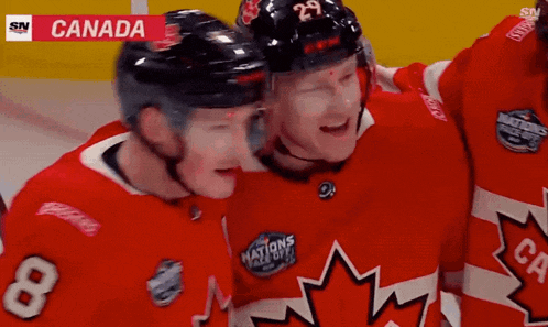 a hockey player with the number 8 on his jersey hugs another player