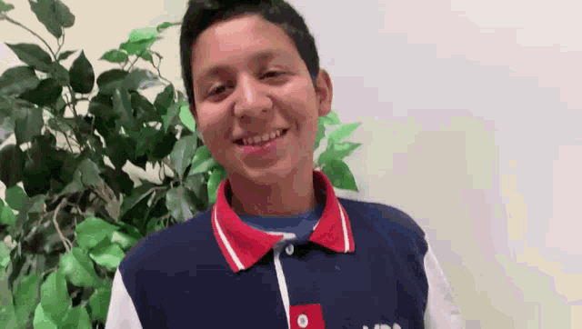 a young man wearing a blue shirt with the word tommy on it