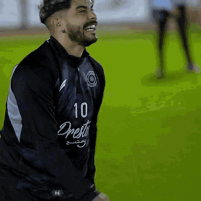 a man wearing a jersey with the number 10 on it is smiling