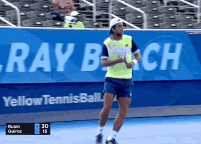 a man in a green shirt is playing tennis in front of a sign that says ray beach