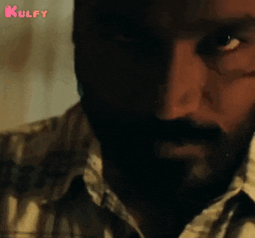 a close up of a man 's face with a beard and a tear coming out of his eye .