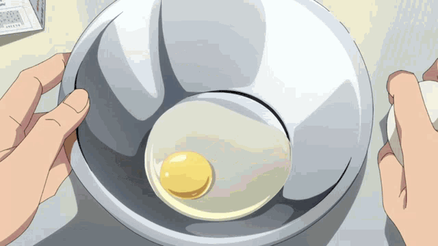 a person is cracking an egg into a bowl with a box in the background that says ' eggs ' on it