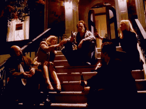 a group of people sitting on a set of stairs in front of a building