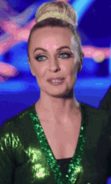 a woman in a green sequined dress is making a face
