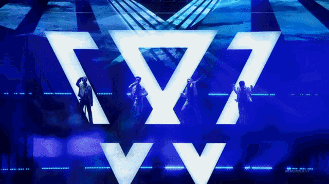 a group of people are standing in front of a blue background with the letter w on it