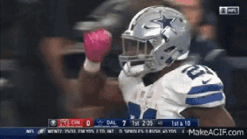 a football player wearing a cowboys helmet is holding a pink glove in his hand .