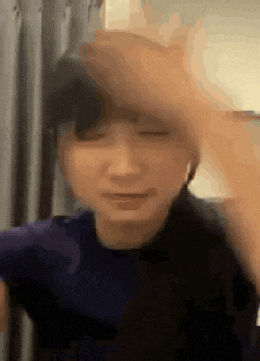 a close up of a person 's face with their eyes closed and their hand on their head .