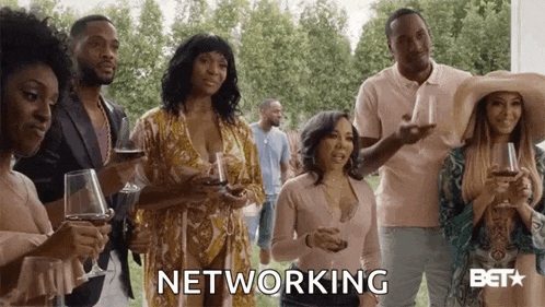 a group of people standing next to each other holding wine glasses and the word networking .