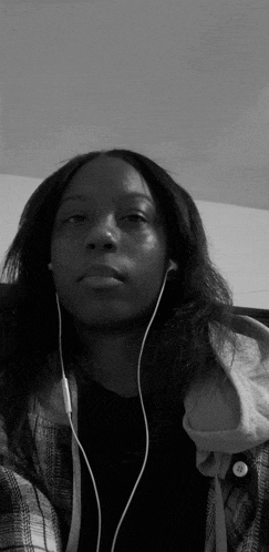 a black and white photo of a woman wearing headphones and a plaid shirt