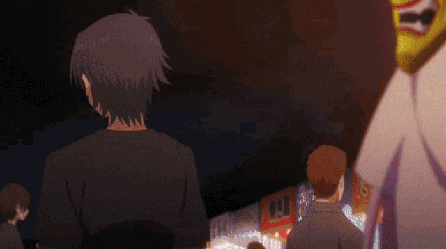 a man in a black shirt stands in front of a crowd of people