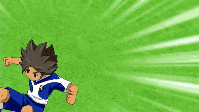 a boy in a blue and white uniform is playing soccer on a green field