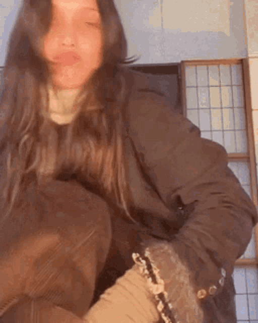 a woman with long hair is wearing a brown jacket and brown boots