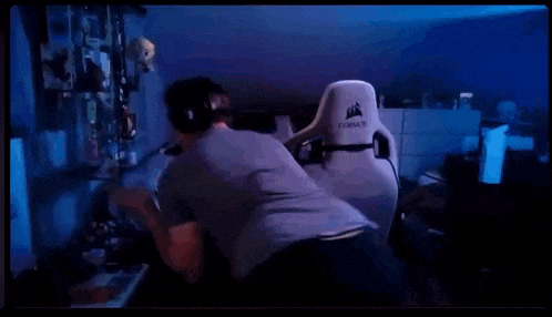 a man wearing headphones is standing in front of a corsair gaming chair in a room .