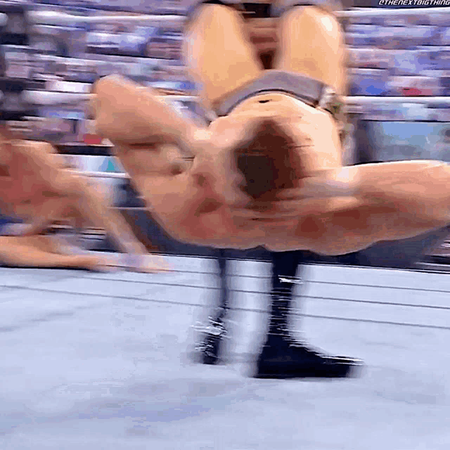a wrestler is doing a handstand in a ring