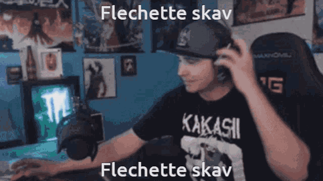 a man wearing a kakashi shirt is sitting in front of a computer