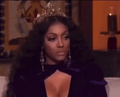a woman wearing a tiara and a purple dress is sitting on a couch