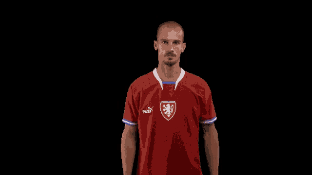 a man is wearing a red puma shirt