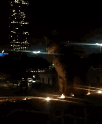 a blurred image of a person walking in the dark with a building in the background