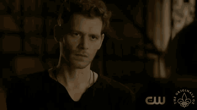 a close up of a man 's face with the cw logo in the corner