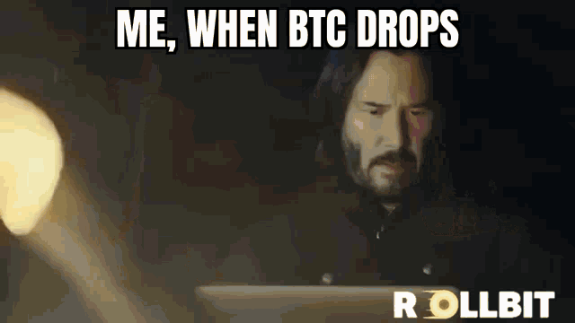 a man with a beard is sitting in front of a laptop with the words me when btc drops on the screen