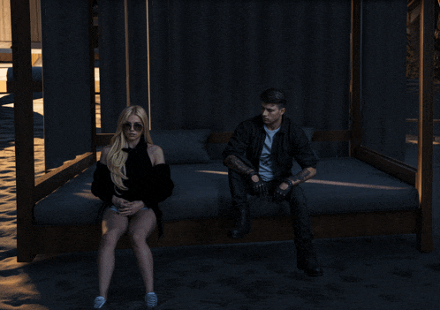 a man and a woman are sitting on a bed