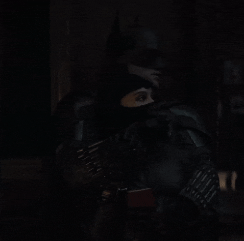 a woman in a catwoman costume is standing in the dark