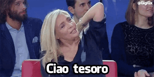 a woman is sitting in a crowd and says ciao tesoro in a foreign language