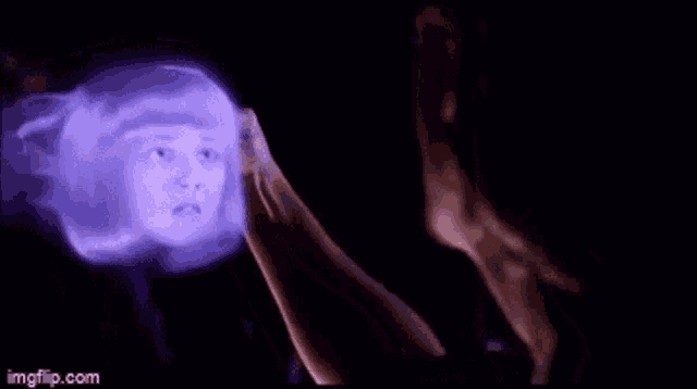 a man in a green shirt is holding a purple object in his hands .
