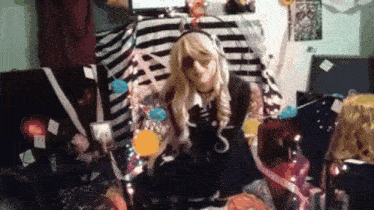 a woman in a costume is sitting on a couch surrounded by balloons and gifts